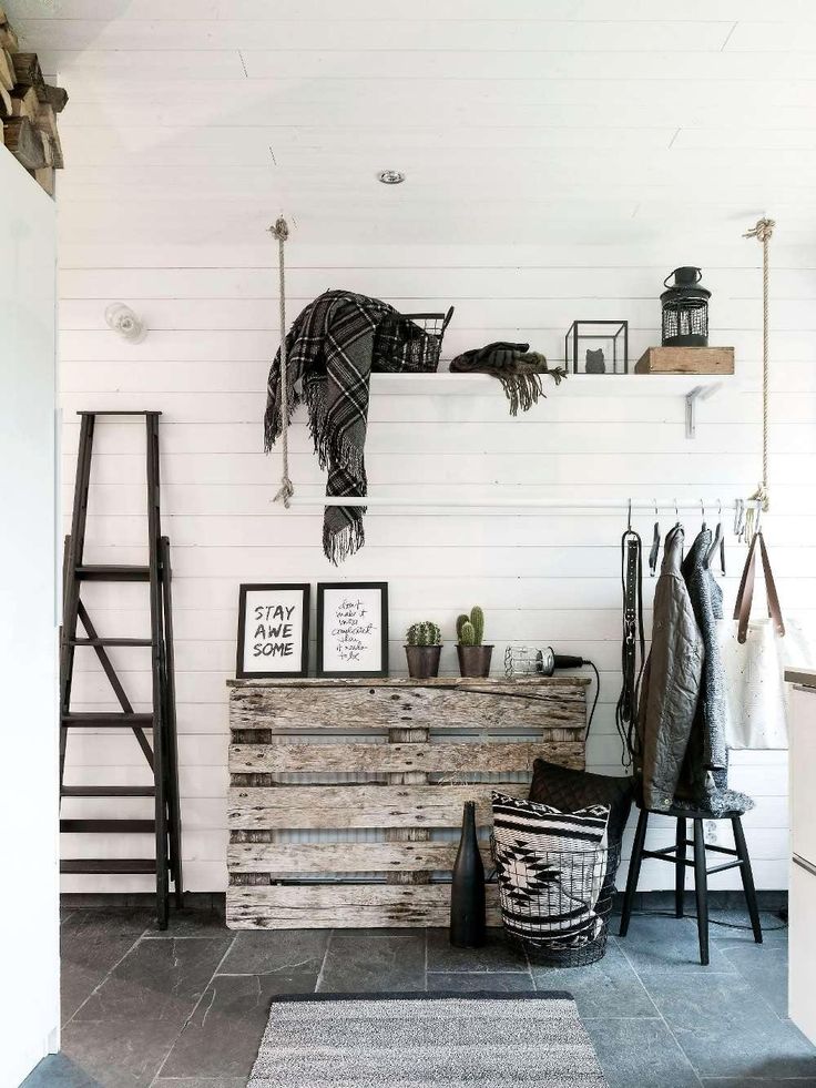 Shiplap entryway with weathered wood chest of drawers, black ladder and hanging coatrack
