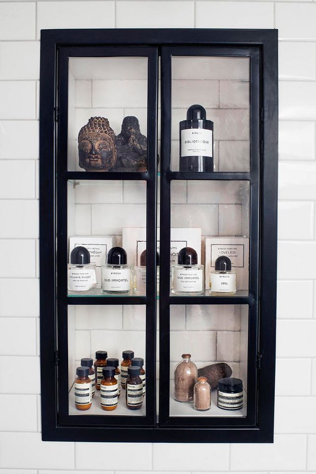black cabinet with Byredo toiletries and white subway tile