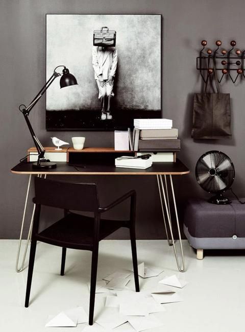 concrete gray wall with black and white statement art over minimalist desk