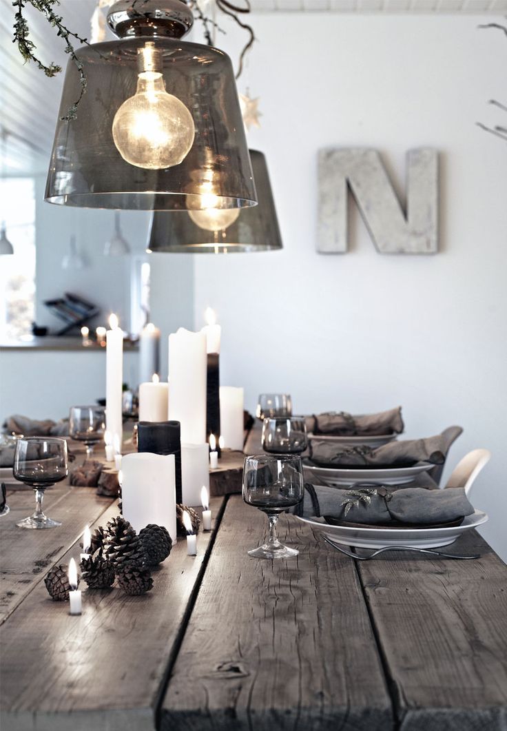 glass lamps hanging over an old wooden table with candles