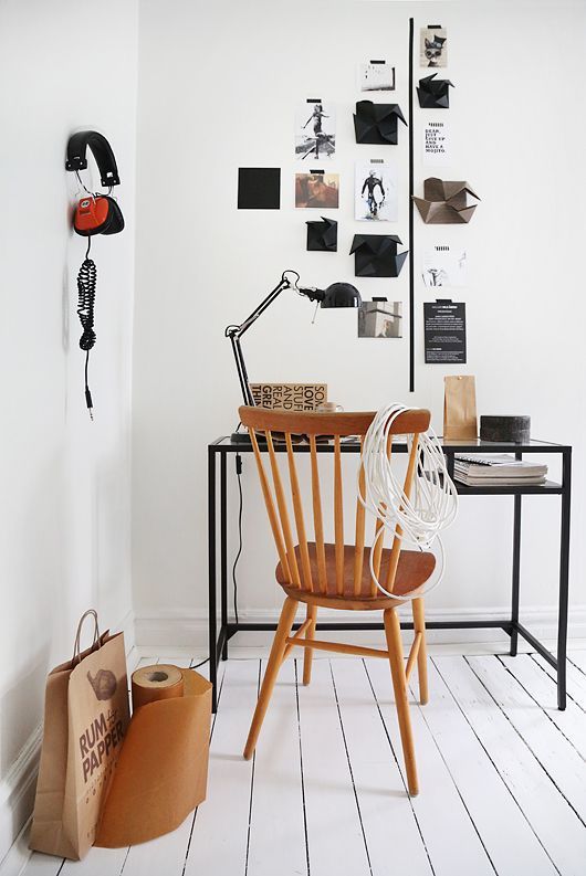 minimalist gallery wall of polaroids over desk with wooden chair