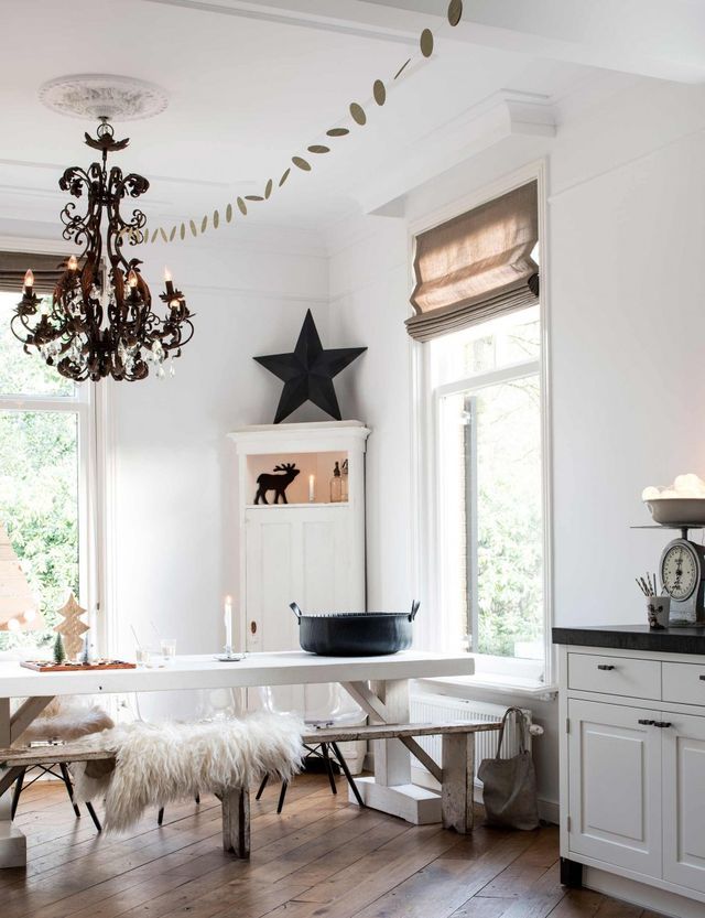 Beautiful white room with iron chandelier and flokati throws on bench