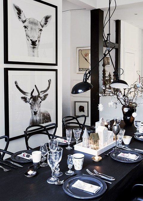 Dining table with black and white animal prints, modern black chandelier and small Nativity scene on table