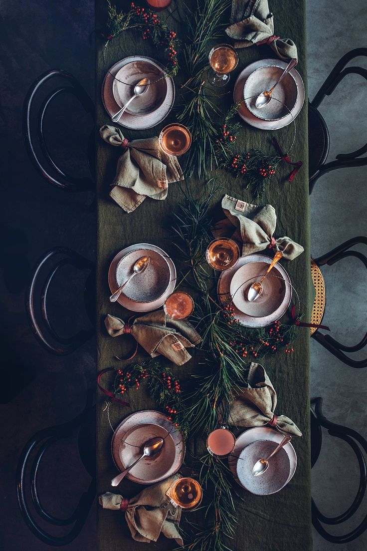 Tablescape of delicious soup with gold flatware, dried fruits and greenery centerpieces