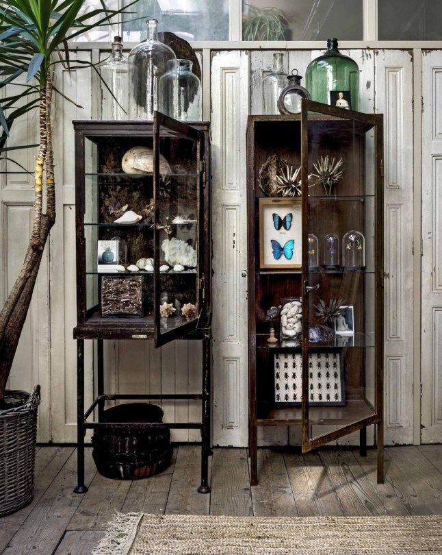 Matching vintage curio cabinets with green glassware and steampunk ephemera inside
