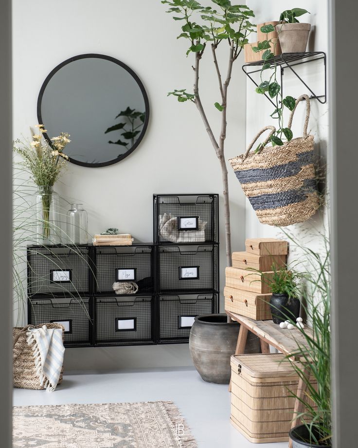 Bathroom with round mirror and industrial-style storage with fig tree and natural grasses in vases