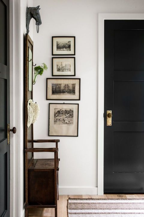 Entryway with gallery wall of vintage photos and wooden hall tree