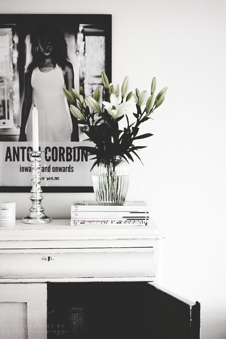 Graphic black and white post with simple white flower arrangement in a glass vase with silver candlestick