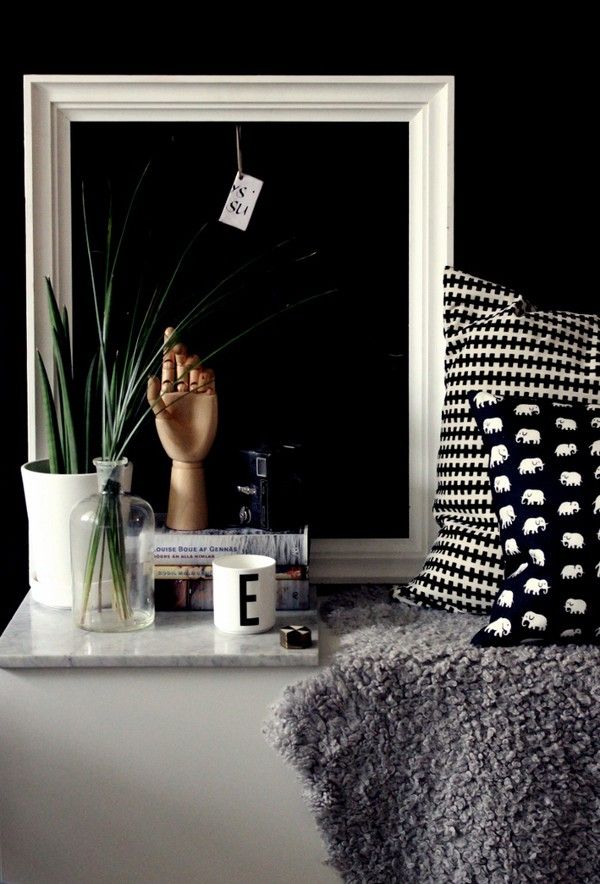 Empty white frame with a botanical vignette and deep black wall