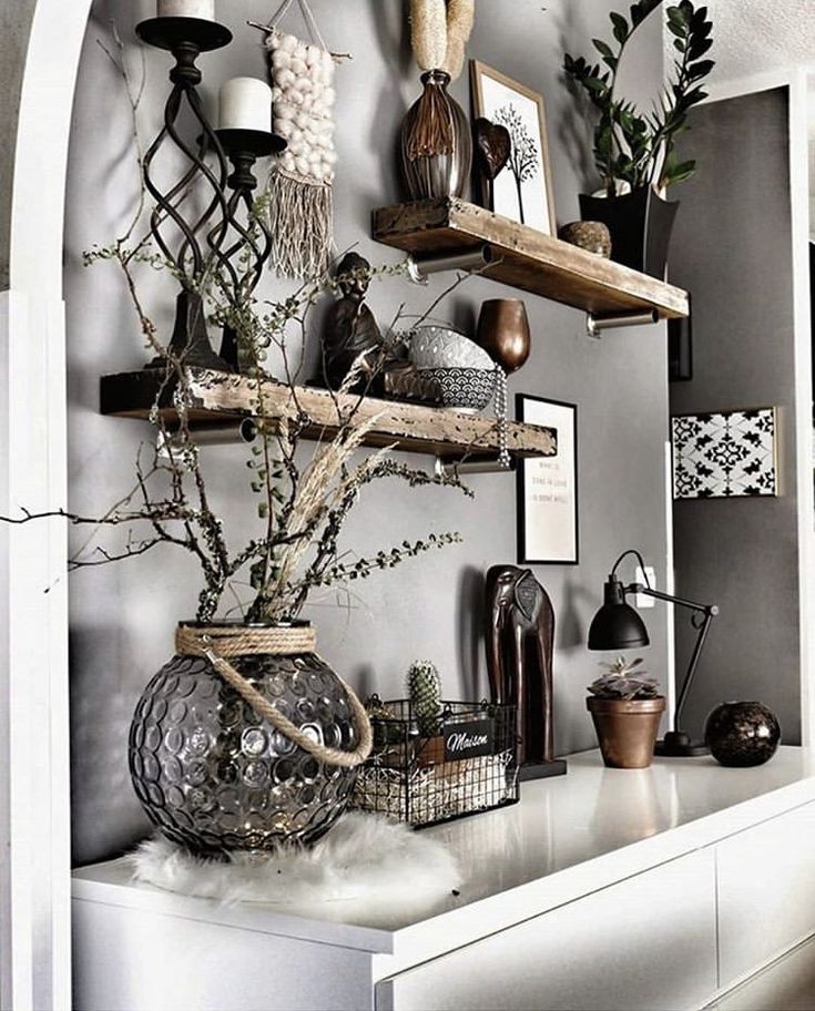 Beautiful Scandinavian-inspired shelf with bubble glass vase of ranches, candles and rough wooden shelves