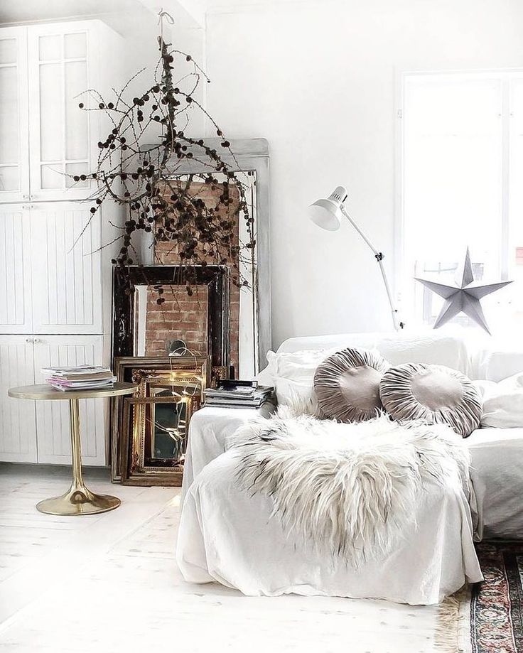Light bright living room with natural branch chandelier and slipcovered sofa with white flokati throws