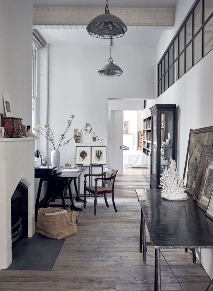 Light-filled, airy entryway with metal console table and white fireplace