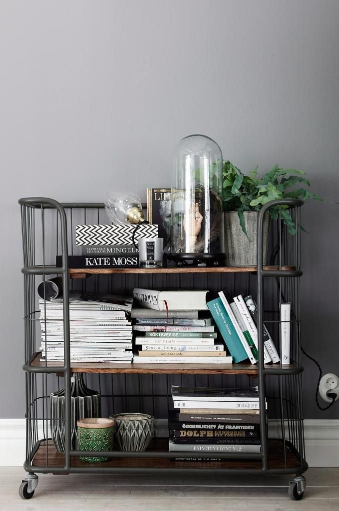 Industrial steampunk rolling cabinet with stacks of books, plants and candles