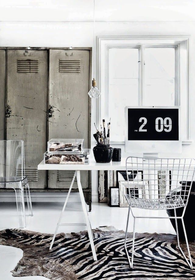 Home office with vintage metal lockers, zebra rug, modern white desk and mac with vintage alarm clock screensaver