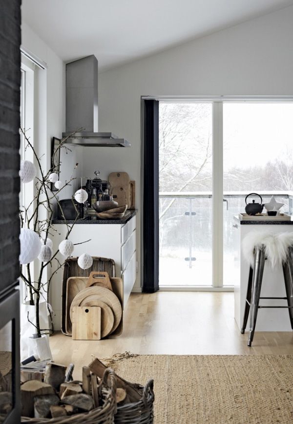 Light bright Scandinavian kitchen with huge picture window looking out on a snowy field