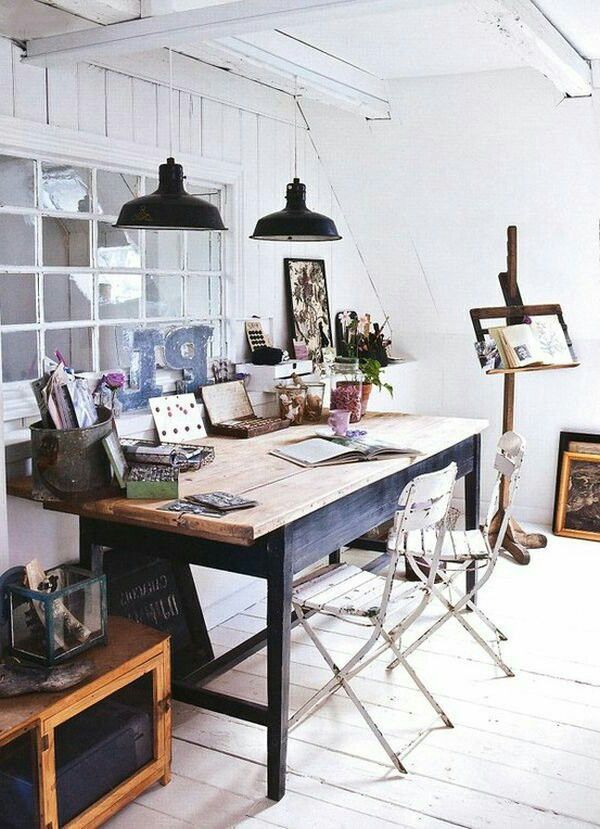 Beautiful light-filled home office with white wood walls, antique desk, chipped bistro chairs and 2 hanging pendant lights