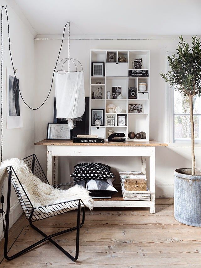 Corner nook with black wire chair with flokati throw and hanging simple white fabric pendant lamp