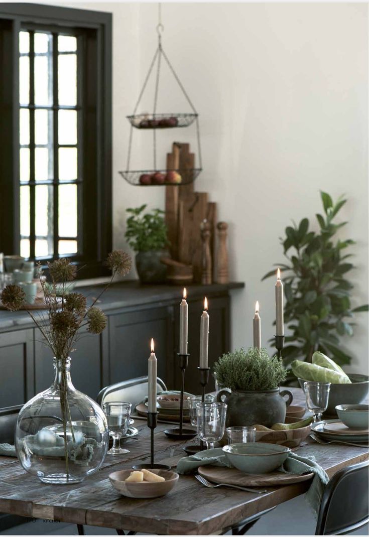 Beautiful dining table set with candlesticks and vases of greenery