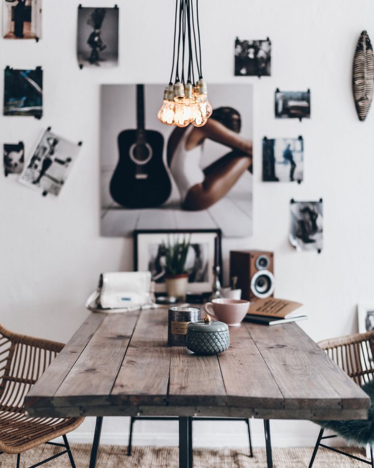 Wooden table with gallery wall and chandelier made of cluster of hanging Edison bulbs on wires