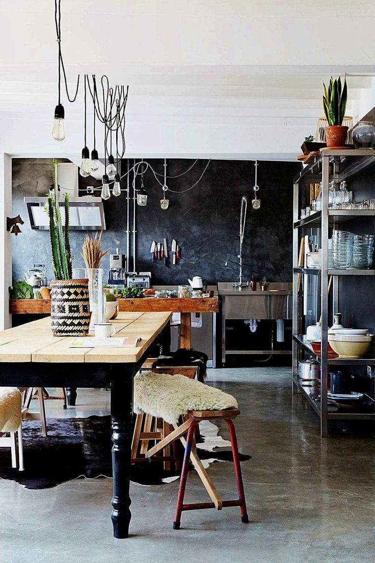 Eclectic boho kitchen with wooden table and hanging Edison bulb chandelier on black wires