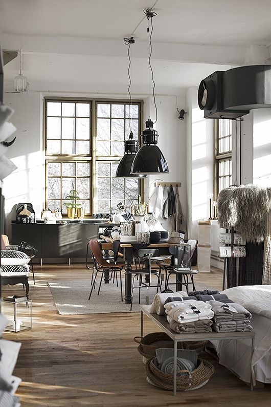 Light sunny loft kitchen with oversized windows and 2 giant pendant chandeliers over table