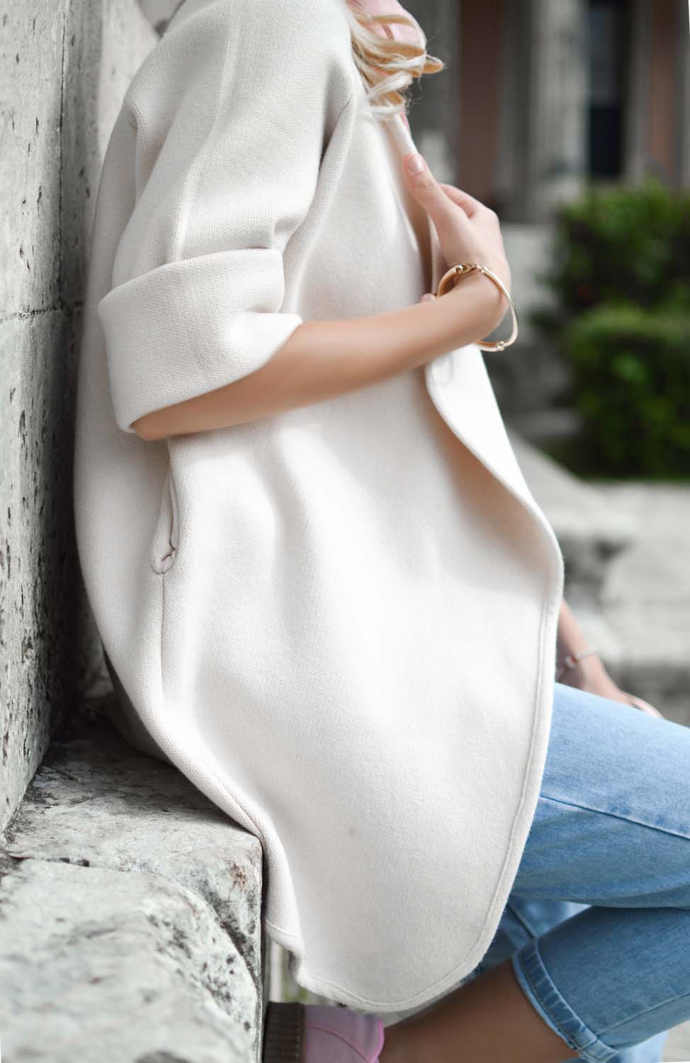 Woman in oversized tailored white shirt with jeans, from chest down