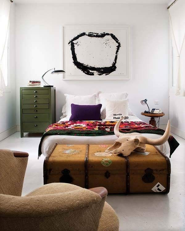 Eclectic bedroom featuring a tribal blanket, animal skull, and abstract art.