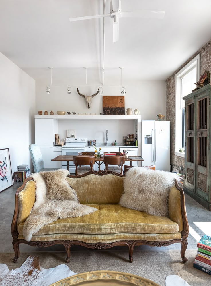 Cozy boho living room with layered rugs, rattan chair, and warm neutral textiles creating a relaxed, inviting atmosphere.