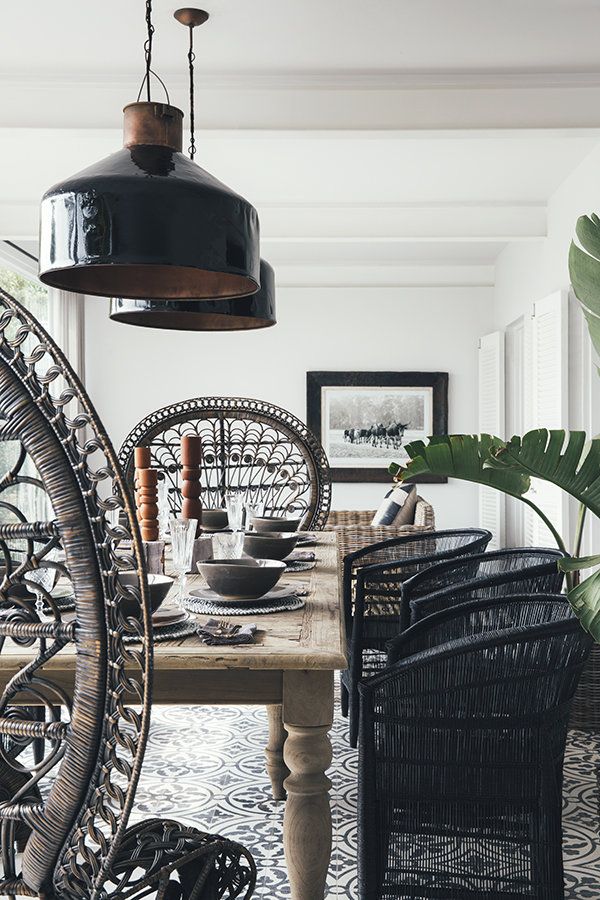 Open kitchen shelving styled with dark plum and emerald green vases, holding preserved dark foliage and dried magnolia leaves.