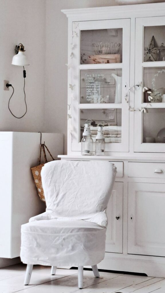 A clean-lined contemporary sofa featuring a crisp, snugly-fitted white canvas slipcover, styled with neutral pillows and set against a minimalist interior backdrop.