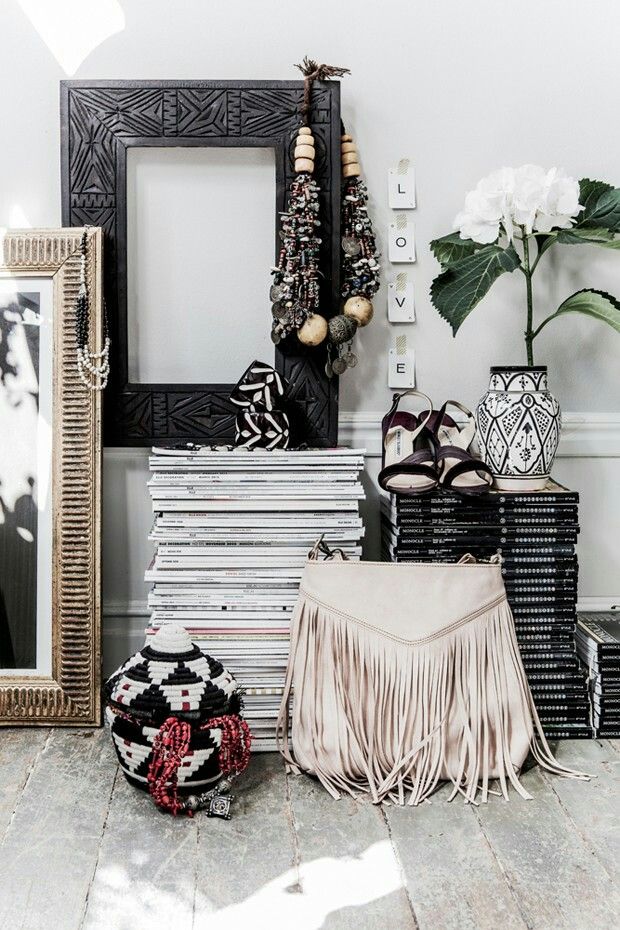 A floor-to-ceiling bookshelf styled with colorful book spines, clusters of amethyst and quartz, brass bells, and a pothos plant cascading down the side.
