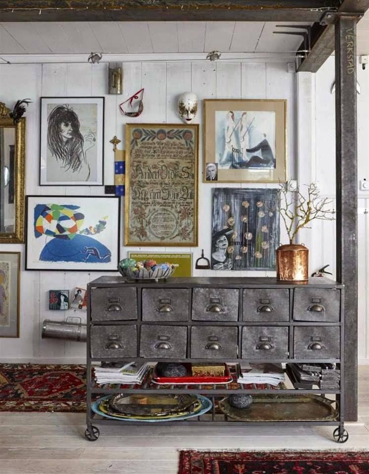 A vintage oak library card catalog with brass pull handles used as a media console, styled with a modern ceramic lamp and a stack of art books in a bright, contemporary living room.