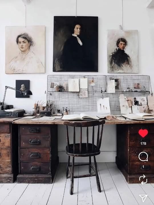 A curated gallery wall featuring a mix of modern abstract line art and one small, ornate gilded frame containing a vintage portrait of a woman, creating a high-contrast focal point in a contemporary dining room.