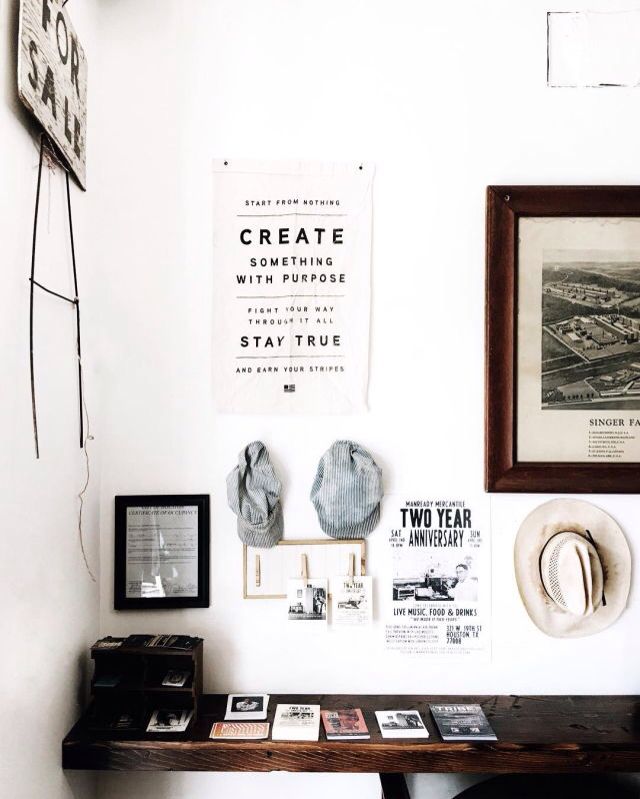 A bright, airy home office featuring a vintage mid-century modern teak desk, a cognac leather chair, and a large potted fiddle leaf fig plant in a terracotta pot against a soft cream-colored wall.